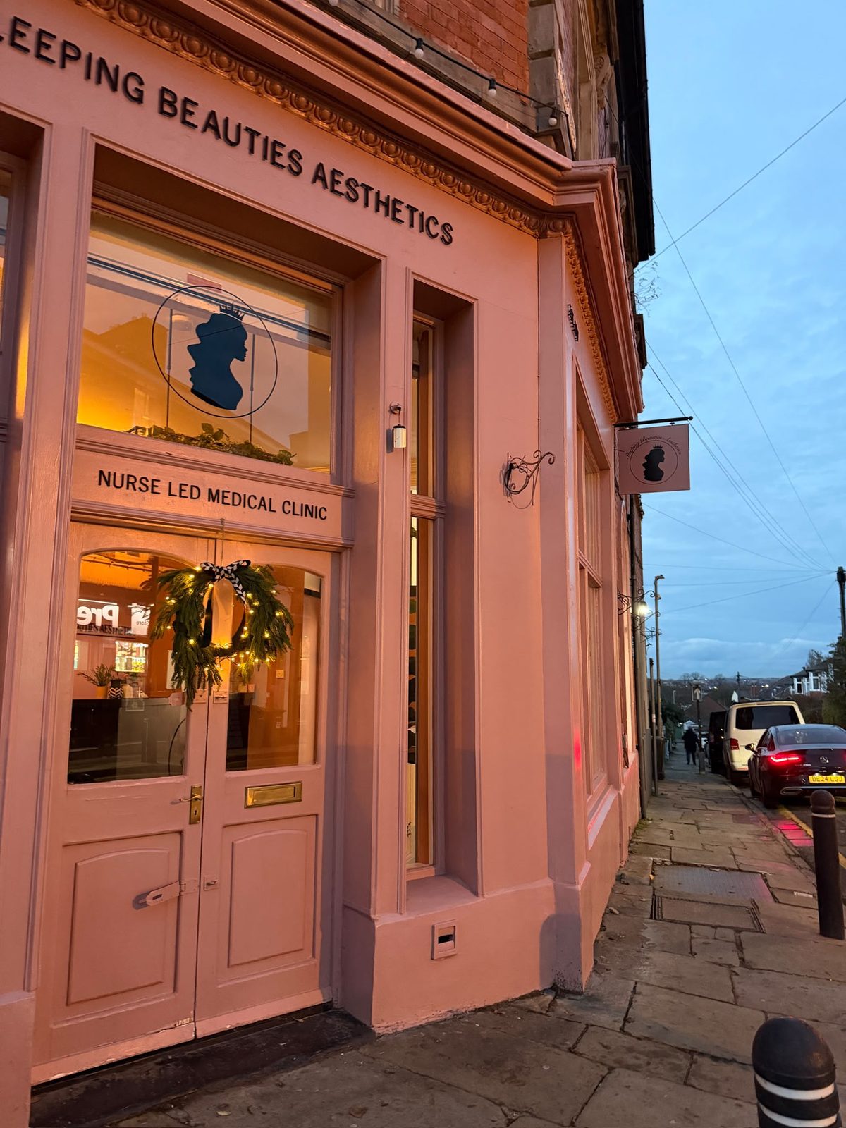 The pink front door and nurse led medical clinic signage at Sleeping Beauties Aesthetics, Oxton