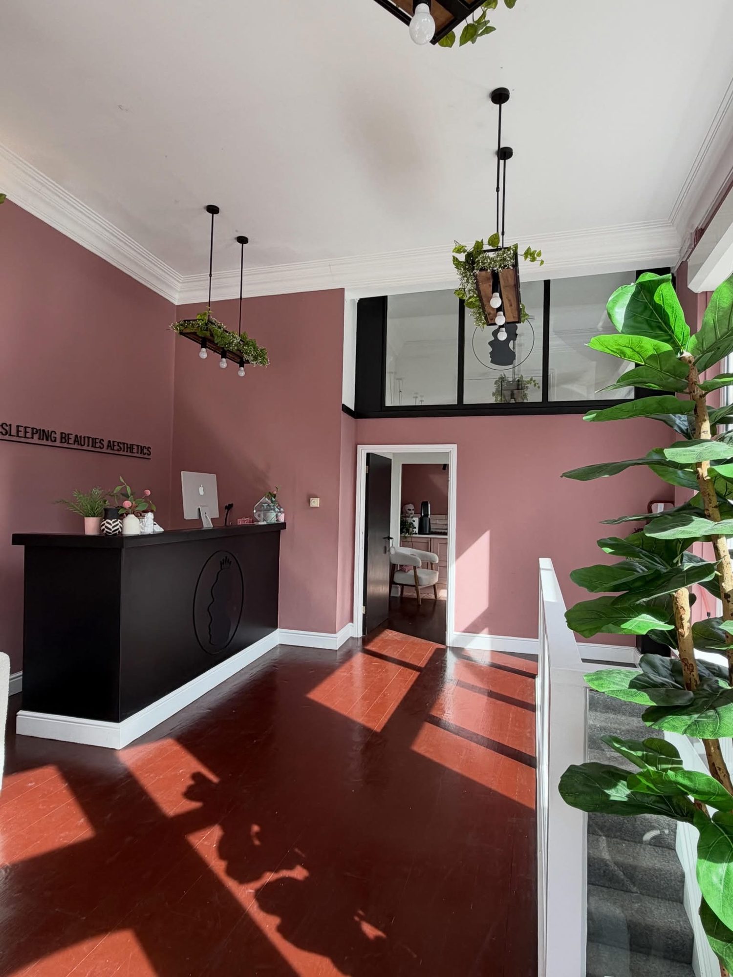 Reception at Sleeping Beauties Aesthetics with blush walls and black desk